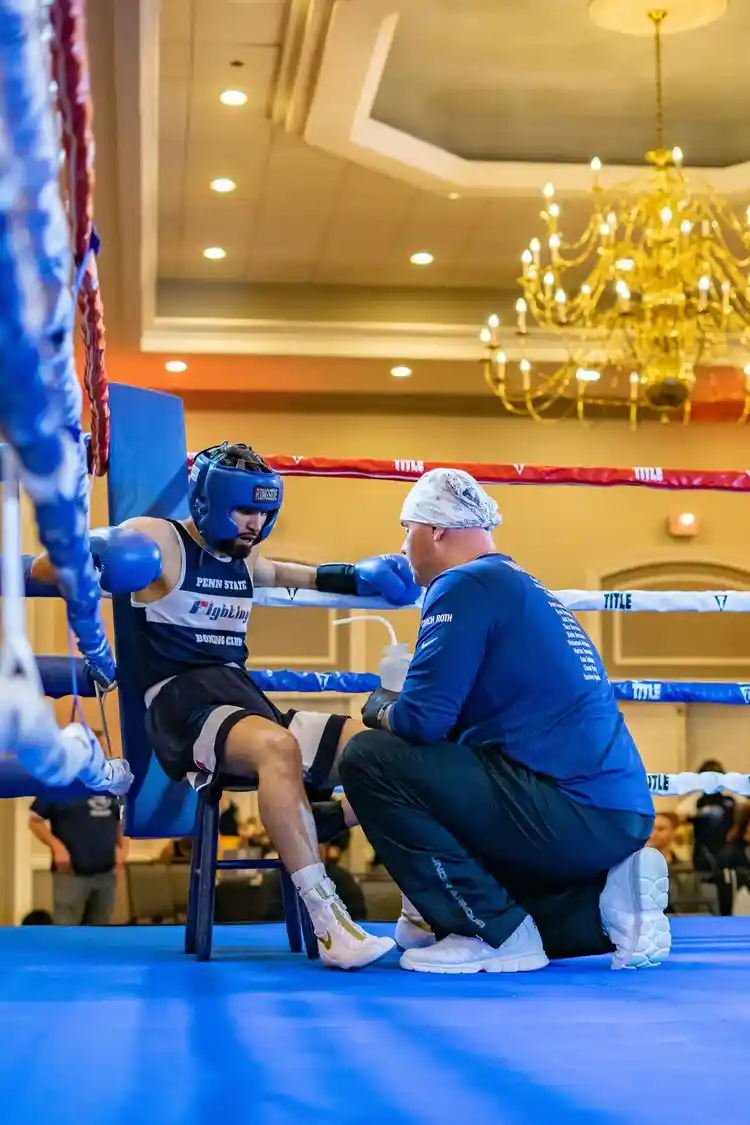 Coach Derek Roth cornering a boxer during a fight