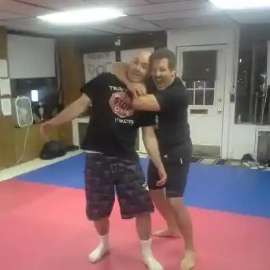 Coach Derek Roth striking a fun pose with a friend